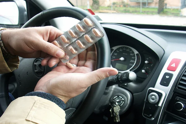 Řidič v ruce drží prášky — Stock fotografie