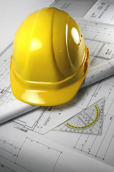 Vue d'angle de certains plans de construction et d'un casque jaune — Photo