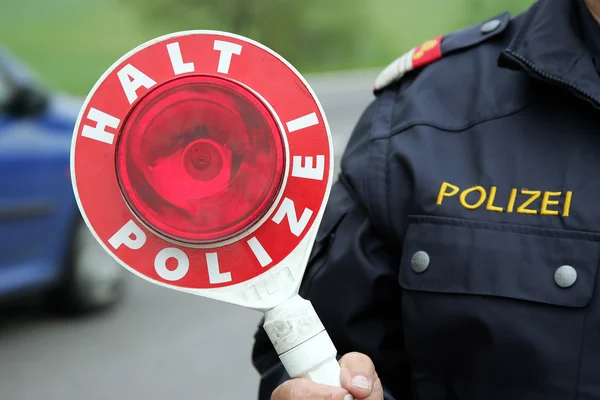 Stop sign by a police man — Stock Photo, Image