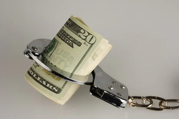 Handcuff and dollars — Stock Photo, Image