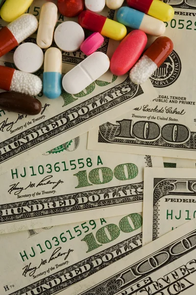 Pillen van verschillende kleuren op geld achtergrond. — Stockfoto