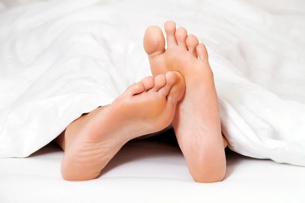 Nohy v posteli — Stock fotografie