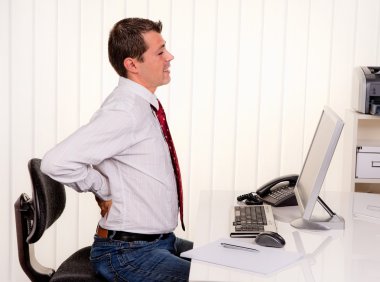 Man in office with back pain clipart