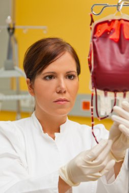 Nurse in hospital with blood products. clipart