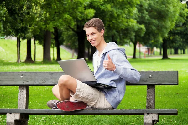 Підліток з ноутбуком на відкритому повітрі — стокове фото