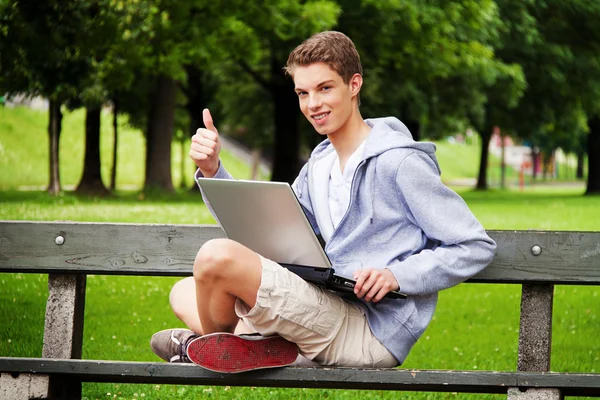 Tonåring med laptop utomhus — Stockfoto