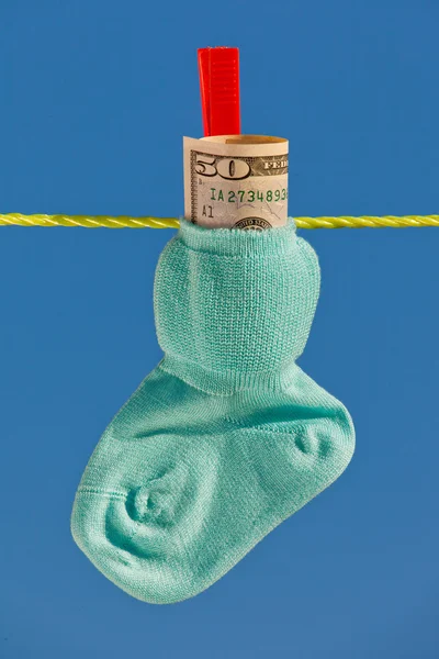 Детские носки на веревке с долларом — стоковое фото