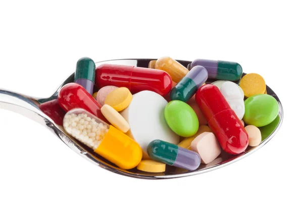 Tablets and medicines on spoon — Stok fotoğraf