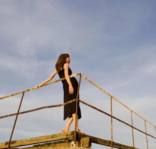 Girl on the ruins of the pier — Stock Photo, Image
