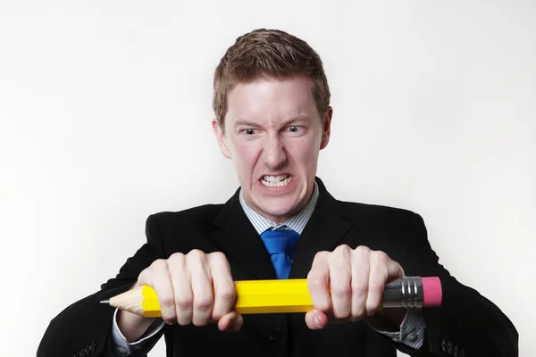 Man trying to break his large pencil — Stock Photo, Image