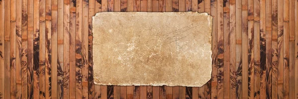 Old damaged paper on a wooden background — Stock Photo, Image