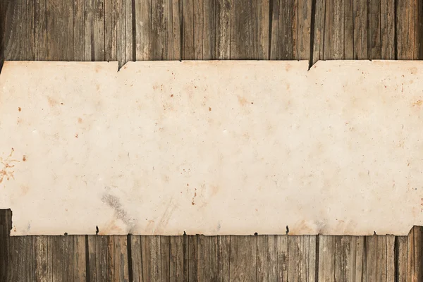 Rollo de papel viejo rasgado sobre un fondo de madera — Foto de Stock