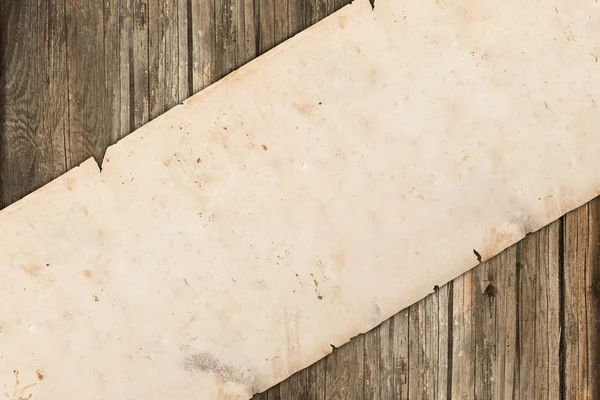 Rotolo di carta vecchio danneggiato su uno sfondo di legno — Foto Stock