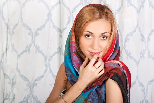 Stijlvolle jonge vrouw in een kleurrijke sjaal — Stockfoto