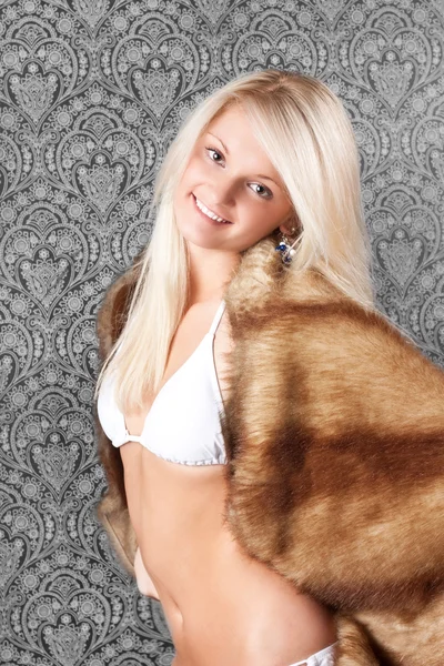 Vrij blond meisje in witte bikini en een bontjas — Stockfoto