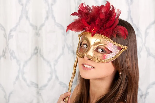 Pretty young brunette girl in an elegant mask — Stock Photo, Image