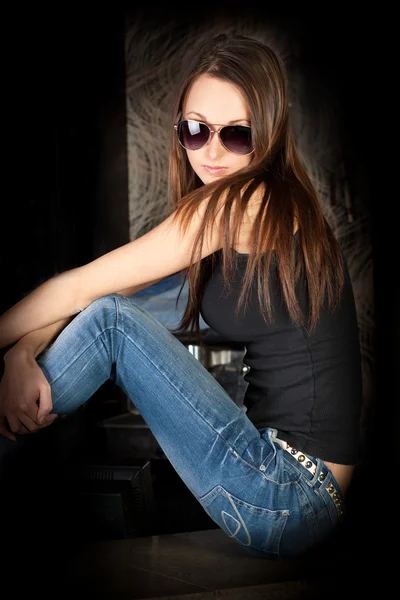 Sexy jeune brune dans des lunettes de soleil élégantes et un jean bleu — Photo