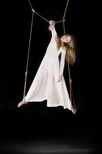Young woman gymnast in white dress on rope — Stock Photo, Image