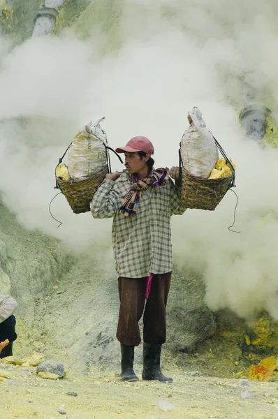 Trabajador que lleva azufre dentro del cráter Ijen — Foto de Stock