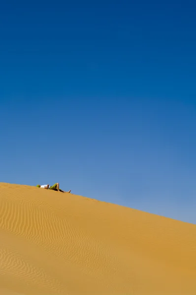 Férfi egyedül fekszik a sivatagban. — Stock Fotó