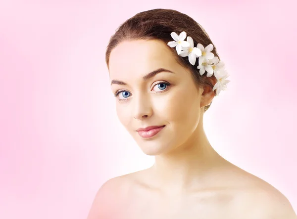 Schöne Frau mit Blumen im Haar und reiner Haut — Stockfoto
