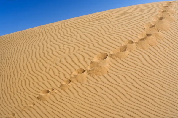 Pegadas humanas na areia amarela — Fotografia de Stock
