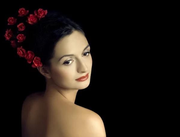 Schönes Mädchen mit roten Blumen im Haar — Stockfoto