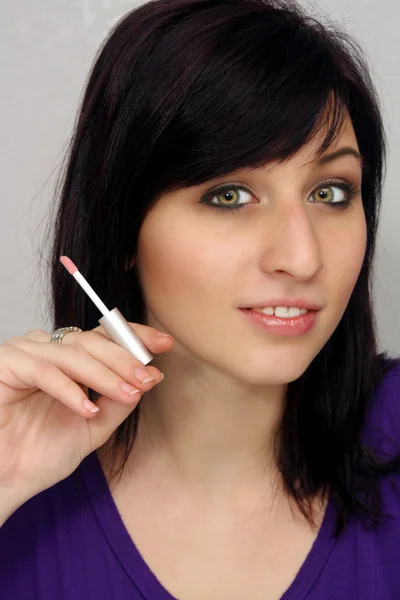 Güzel bir genç kadın kozmetik aplikatör tutar — Stok fotoğraf