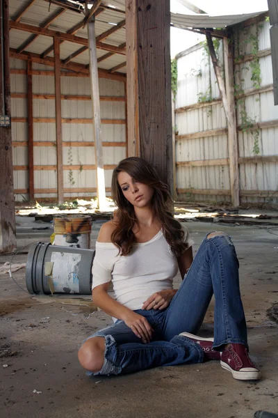 Linda morena sentada em um armazém abandonado (1 ) — Fotografia de Stock
