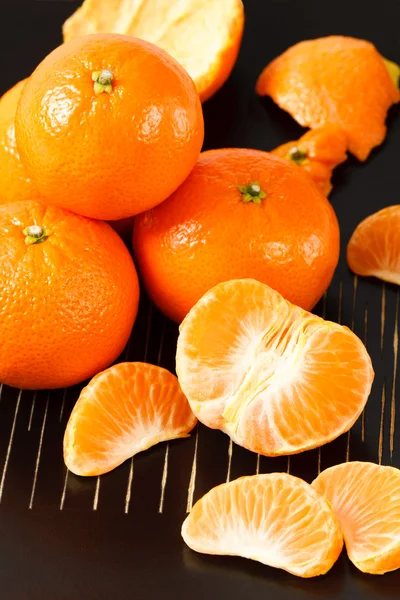 Sunne mandarinappelsiner på svart bakgrunn – stockfoto