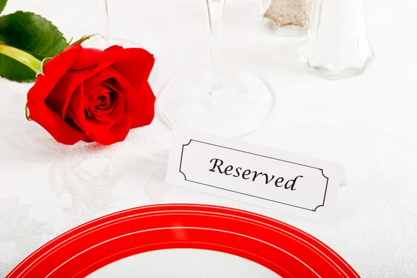 Close up van gereserveerde restaurant tabel met rode roos — Stockfoto