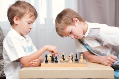 Two boys playing chess at home