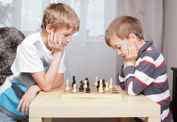 Two boys playing chess at home — Stockfoto