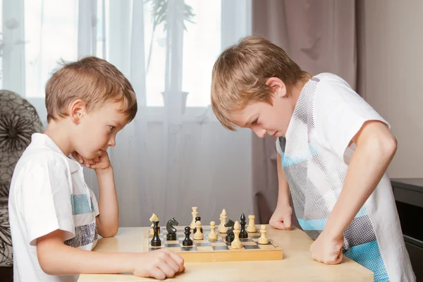 Two boys playing chess at home — Stok fotoğraf