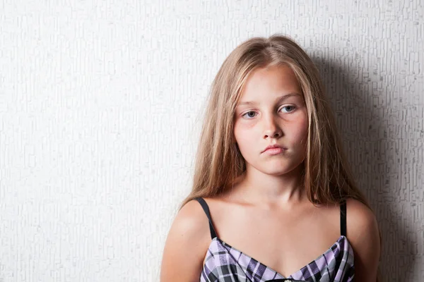 Porträt eines traurigen Mädchens an der Wand — Stockfoto