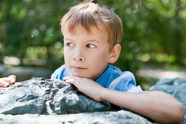 Portret van trieste jongen op de rotsen. — Stockfoto