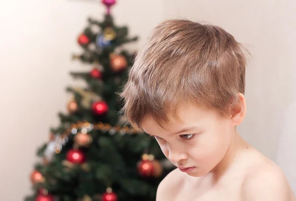 Sad little boy about the Christmas tree. — Stock Photo, Image