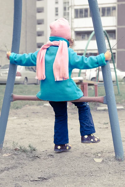 Kicsi lány, kék kabát a játszótér — Stock Fotó