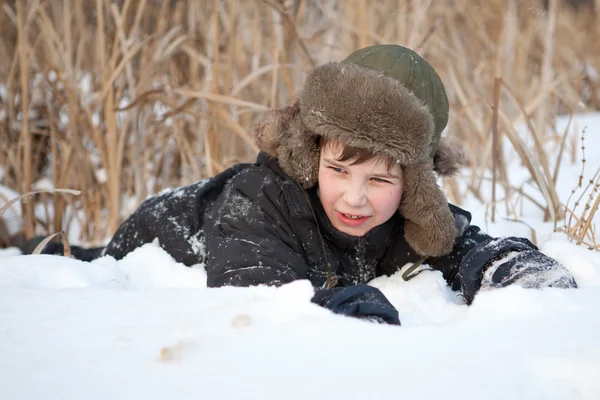 Chłopak leżał na śnieg, zima — Zdjęcie stockowe