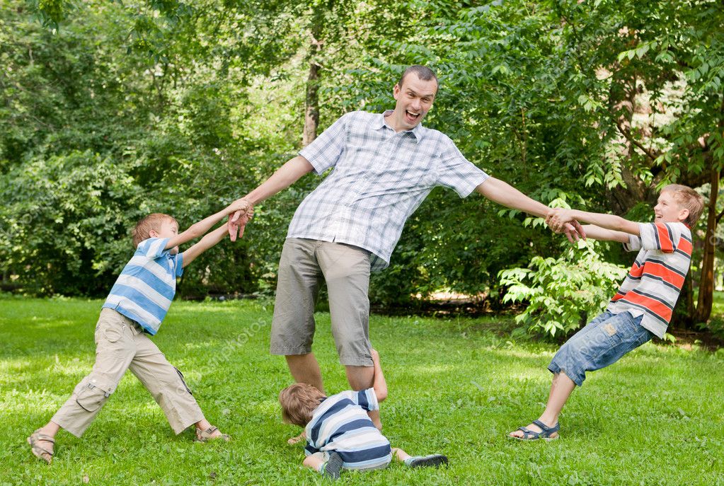 Father and three sons play in the park. — Stock Photo © rimdream #9614059