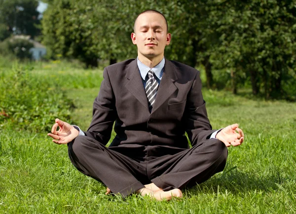 Бизнесмен медитирует на открытом воздухе — стоковое фото