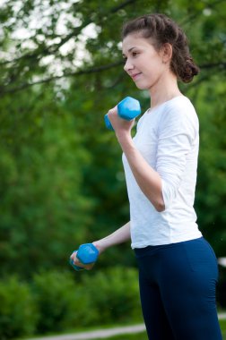 kadın dumbbell ile egzersiz yaparak