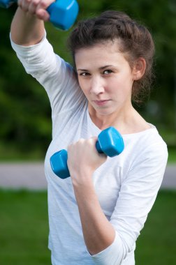 kadın dumbbell ile egzersiz yaparak