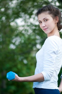 kadın dumbbell ile egzersiz yaparak