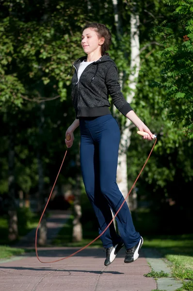 Vrouw met springtouw in park springen — Stockfoto