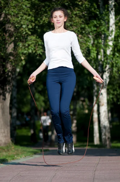 Skoki kobieta z skakanka w parku — Zdjęcie stockowe