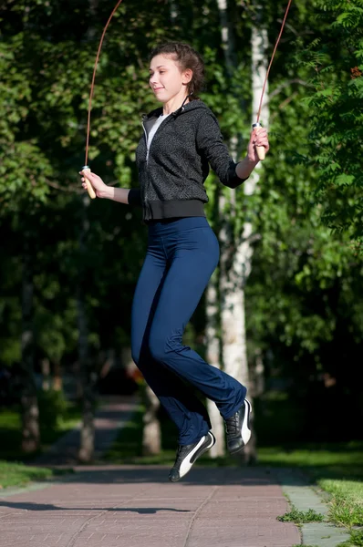 Kadın parkta ip atlama ile atlama — Stok fotoğraf