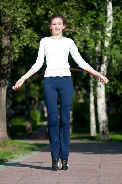 Mulher de salto com pular corda no parque — Fotografia de Stock