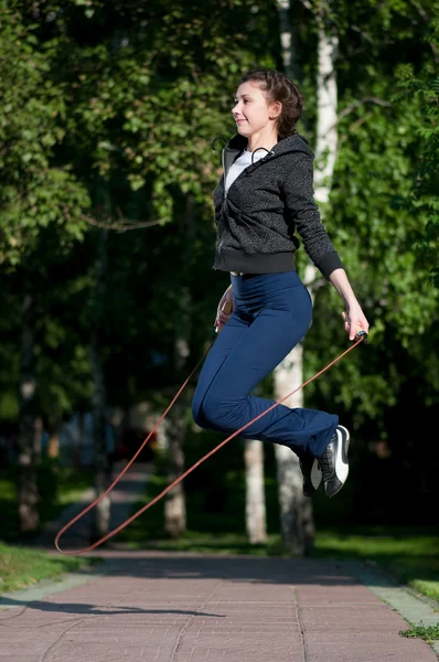Skoki kobieta z skakanka w parku — Zdjęcie stockowe