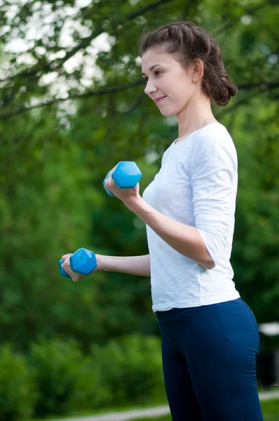Mujer haciendo ejercicio con mancuerna — Foto de Stock